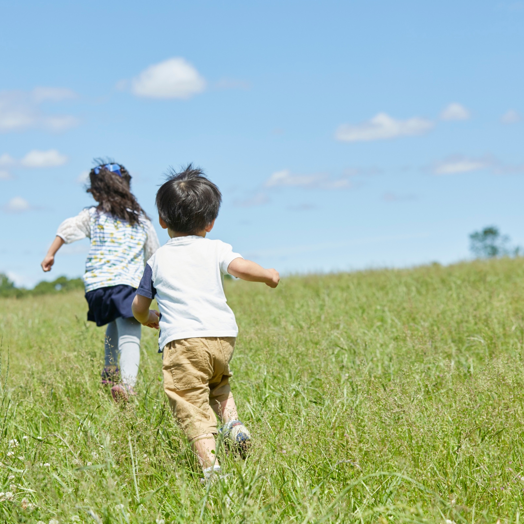 Enfant courant pieds nus dans l'herbe verte